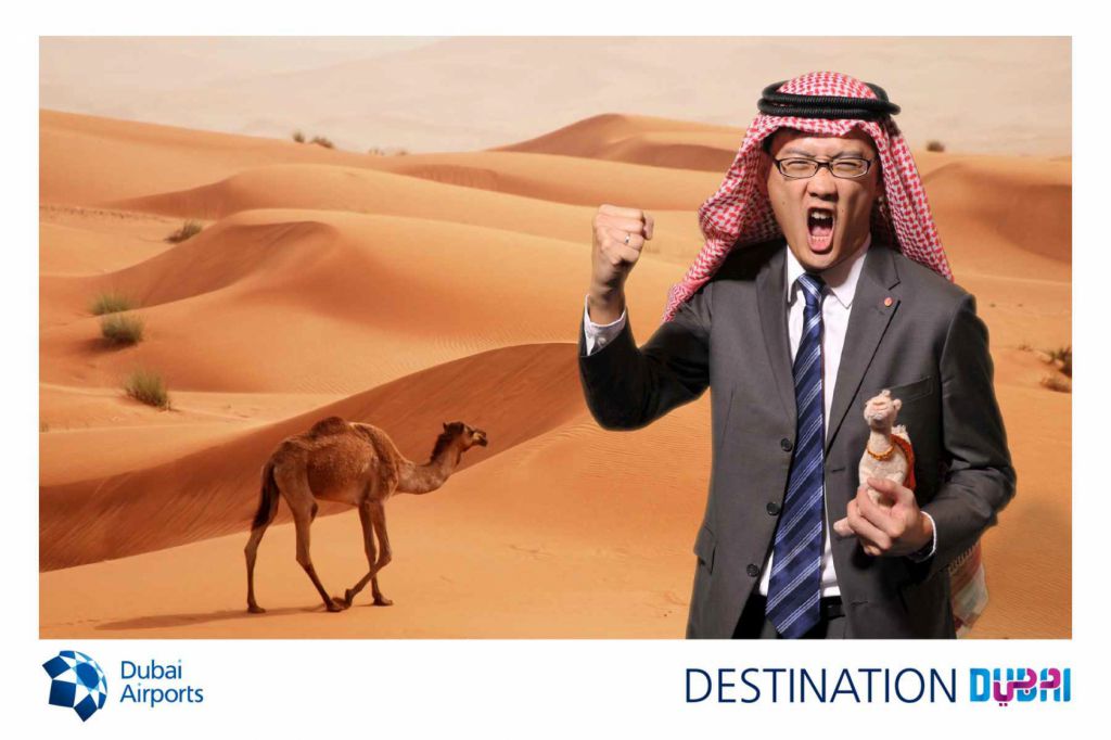 Asian man with stuffed camel screams in desert in dubai green screen photobooth