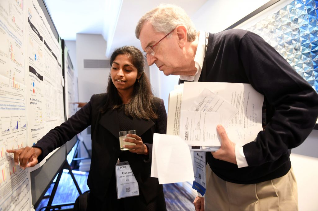 student shows judge her experiment during poster session
