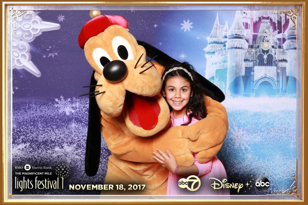 Cute girl poses with Goofy at Disney character meet and greet