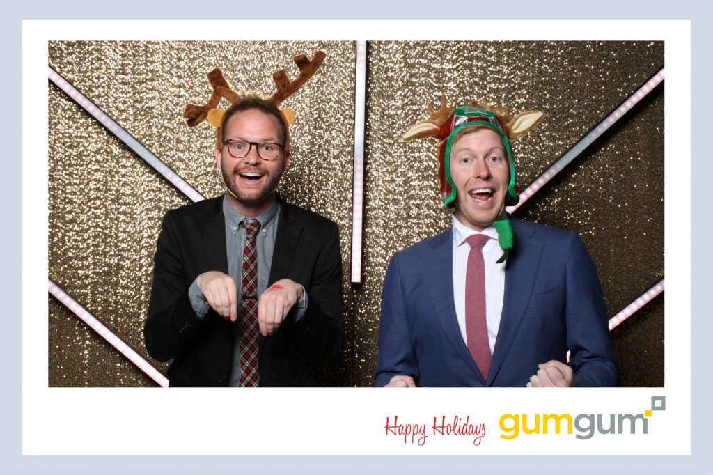 Guests act like reindeer on holiday party photography gold glitter background