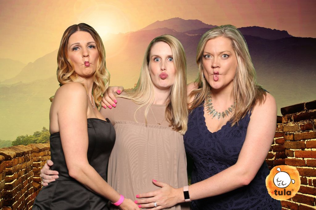 Green screen photo booth at tradeshow features travel backgrounds, women make duck face 