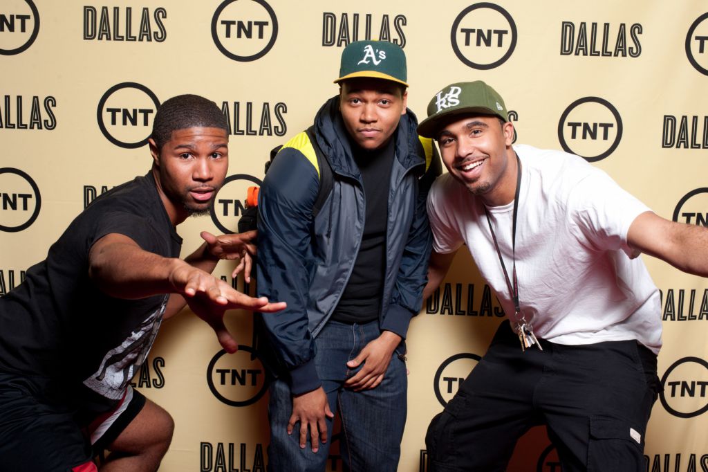 Cool kids strike poses on the step and repeat background for TNT Dallas Rebooted Sneak Peak Chicago movie event